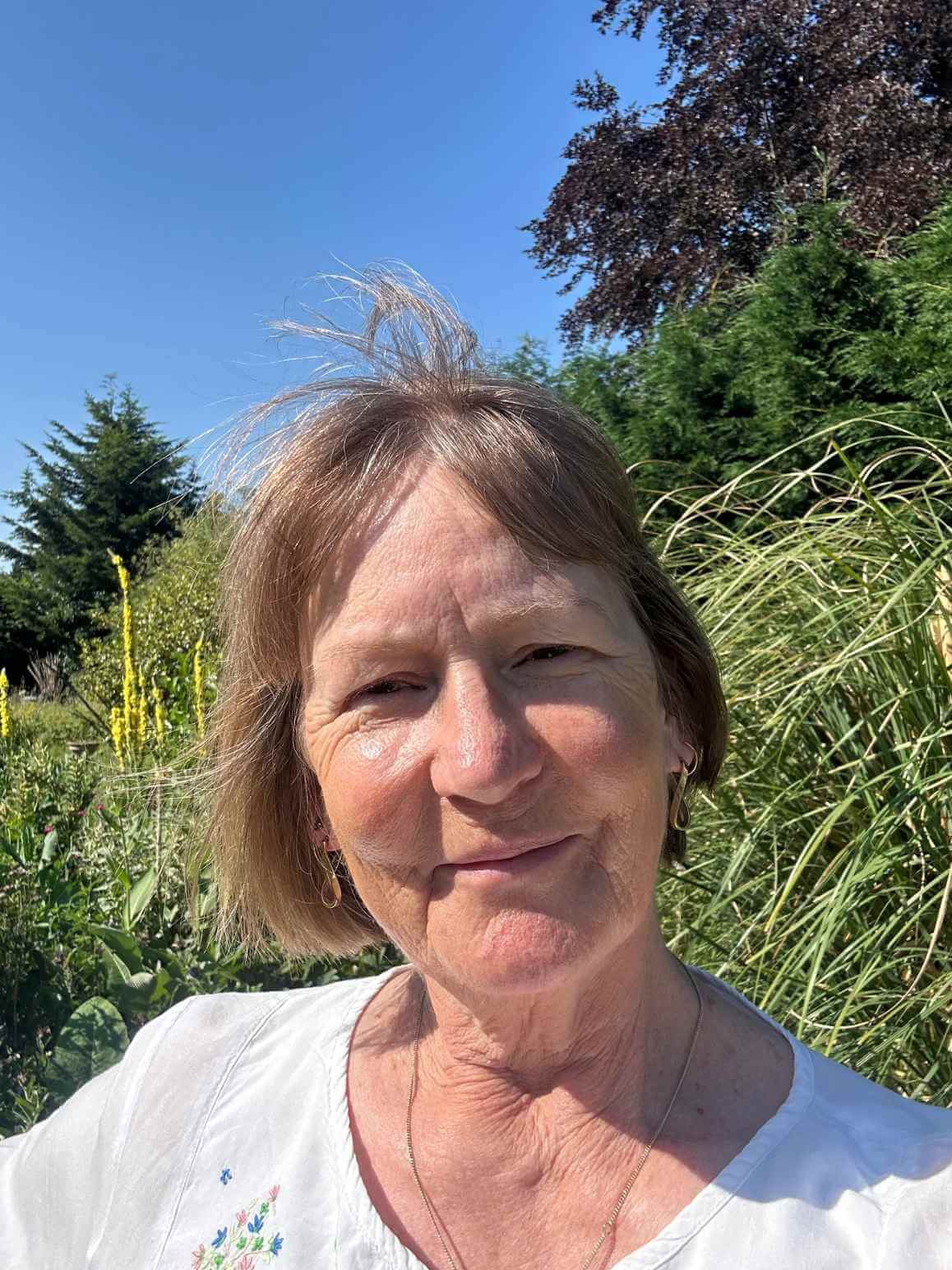 Lorraine Bellis, owner of Herbs of Grace, taking a selfie in her garden.
